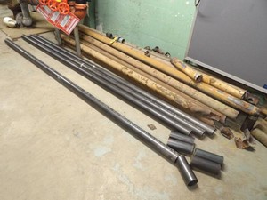 4 LONG BLACK PIECES OF PIPE AND LARGE PILE OF SCRAP PIPE