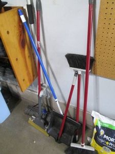 Variety of brooms and dust pans...