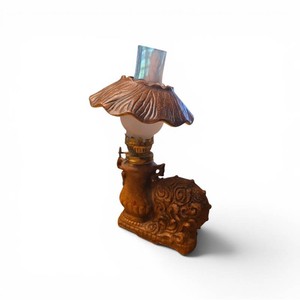 vintage Enesco ceramic oil lamp, typically featuring a brown finish with a decorative spinning wheel motif and a clear glass globe chimney