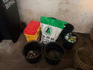 Partial Bag of Fertilizer, Partial Container of Weed Preventer and Five Plant Pots (front two Black Ceramic, back Plastic)