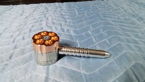 Metal 6 Shooter smoking pipe designed to look like a revolver cylinder with rotating head with 6 individual bowls and a magnetic grinder on bottom