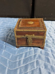 handcrafted vintage wooden storage box with ornate brass fittings. It is commonly used as an antique-style trinket or jewelry chest, showcasing traditional craftsmanship