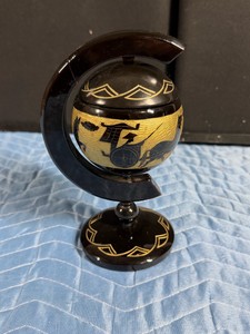 vintage mid-century modern black lacquer globe ashtray, often stylized as a Chinoiserie floating catchall or cigarette server. Popular in the mid-to-late 20th century, these items feature a spherical body nested on a curved axis stand mimicking a traditio
