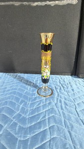 vintage Bohemian Czech glass bud vase, famous for its hand-painted enamel and heavy gilt overlays. Produced mid-20th century (often 1950s1960s), this style features a deep amethyst purple or black glass body with raised 3D moriage floral decorations.