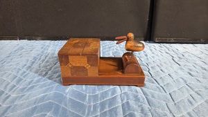 vintage mechanical wooden cigarette dispenser box featuring a novelty pecking-bird mechanism
