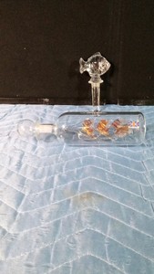 Hand-blown glass bottle containing a delicate ship inside made in Britain and a Mikasa lead crystal Natures Catch wine bottle topper originally produced in Austria