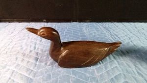 Vintage hand-carved ironwood duck statue featuring a dark wood grain and sleek, minimalist form