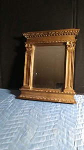 Vintage style glit framed mirror with architectural pediment and column details resembling Neoclassical or regency designs