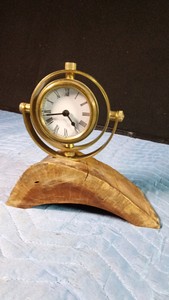 Vintage -style brass gyroscope or gumball desk clock mounted on a curved wood base