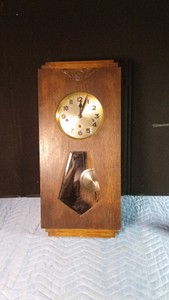Vintage wall chime clock manufactured in Germany during the early 20th century featuring an oak case with apenulum shape window and brass pendulum with wood rod and has key