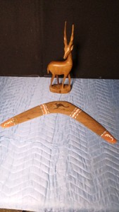 Vintage hand-carved teakwood antelope and an Australian Aboriginal-style wood boomerang featuring hand-painted dot art and carved kangaroo.