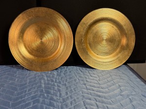 Gold charger plates featuring a textured, spiral concentric ring design