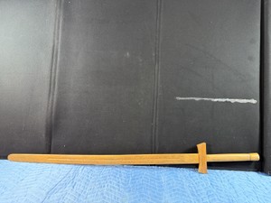 Handcrafted wooden practice sword, often referred to as a bokken or wooden katana, designed for martial arts training or cosplay.