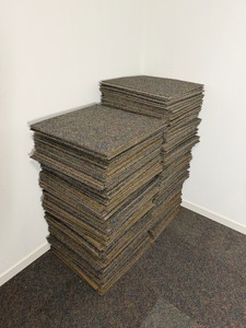 Large stack of multi-colored, low-pile modular carpet tiles (or carpet squares) with a multi-tonal speckled pattern, typically used for DIY flooring installations in commercial spaces or residential basements. Alao comes with Bucket of Carpet Adhesive