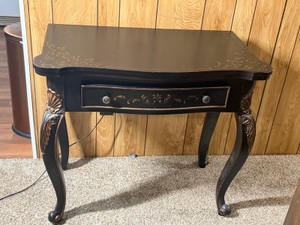 Black lacquer accent table features ornate gold-gilt Chinoiserie floral details and graceful cabriole legs.