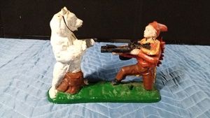 Indian Shooting bear  Cast iron mechanical bank featuring a Native American figure aiming a rifle at a polar bear