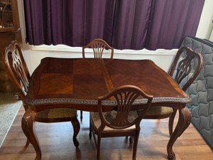 Vintage traditional-style wooden dining room table and chair set, featuring classic formal design elements like Queen Anne-style cabriole legs and decorative openwork chair backs. Comes with 2 leaves