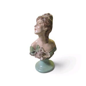 antique ceramic or chalkware bust features a Victorian-style brunette lady adorned with a large pink flower and green dress accent
