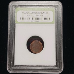 Medieval bronze coin enclosed in a slab