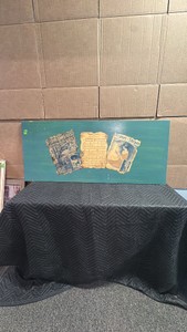 This custom artwork features a turquoise blue backing board adorned with three vintage sheet music