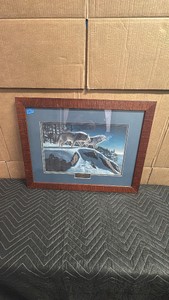 Framed wildlife piece is Moonlight Prowlers, a popular winter-themed print featuring a pack of wolves traversing a snowy cliffside by acclaimed artist Kim Norlien