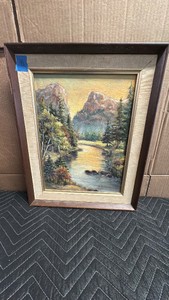 Antique framed oil painting depicts a tranquil mountain river landscape with evergreen pine trees and towering rocky cliffs under a warm yellow sky