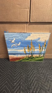 Vintage framed crewel embroidery and long-stitch coastal landscape wall art piece featuring seagulls in flight over a beach and dunes