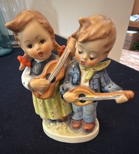 vintage Goebel Hummel Happy Days Figurine (#150 20), featuring a hand-painted ceramic boy and girl singing while playing stringed instruments.