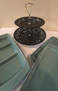 vintage Robert Emig black cast iron two-tier tidbit server featuring ornate classical Greek or mythological figures along the pierced metal trays and food network serving platters