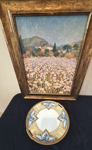 This antique porcelain decorative plate by Reinhold Schlegelmilch (R.S. Germany  Tillowitz) features an Art Nouveau yellow leaf pattern with blue orchid or iris floral accents and a gilded gold rim along with picture of iris by Hazel Baricer