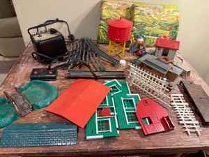Lionel 0 Gauge model train accessories with track pieces, transformer controller, plastic buildings, etc.