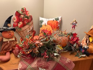 Fall Decorations with centerpiece, pillow, sign, circle tablecloth, and figurines