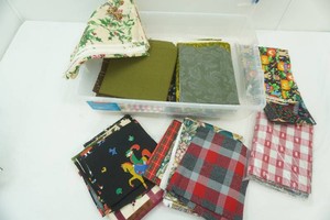 variety of fabric pieces in differant sizes in storage tote with lid