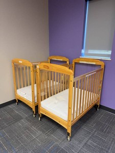 Pair of Compact Wooden Window Crib features clear acrylic panels at both ends for high visibility. Wooden Daycare Baby Cribs With Mattresses on Casters. Each Retails for $375