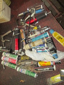 Collection of standard and mini grease guns and a variety of replacement grease inserts