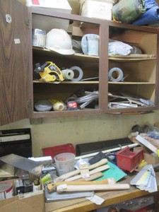 Content of cupboard and benchtop to include a large assortment of construction hardware, ax handles, paint supplies, tape and more