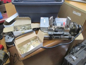 Electric key cutter with various cut keys and key blanks in small covered tote