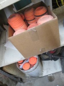 Bucket and box containing an assortment of target practice clay pigeons