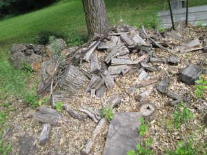 Mountain of weathered logs, cut wood and bark plus misc metal t-posts