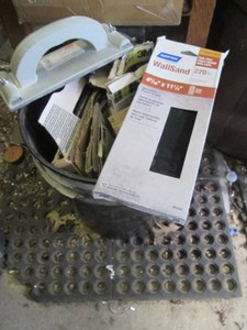 Bucket full of assorted sandpaper and supplies