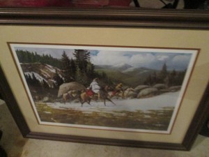Signed and numbered cowboys in the mountains framed print artist name not legible,