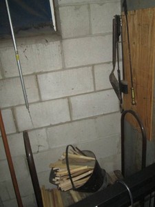 Firewood rack with cut and dried firewood and fireplace tools and ash bucket