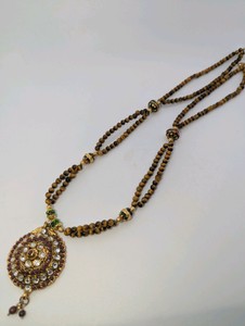 Traditional multi-strand tigers eye bead necklace-ornate gold-plated circular pendant accented with sparkling kundan stones