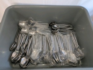 Tub full of new stainless steel spoons