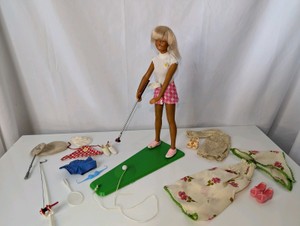 1974 Kenner Dusty The Golf Champion fashion action doll alongside her putting green base, golf club, and various classic outfit accessories