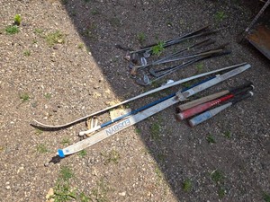 Assorted golf clubs, skis, and baseball bats