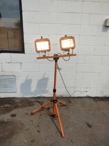 Twin-head portable halogen work light on an adjustable tripod stand.