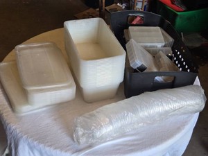 Stack of Plastic Containers, Lids, and Small Organizer Boxes with a Round Clear Cup