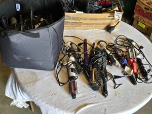Various brands of hair styling tools, including Conair and Revlon curling irons, hair dryers, styling brushes