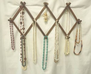 wood jewelry rack with a variety of beaded jewelry
